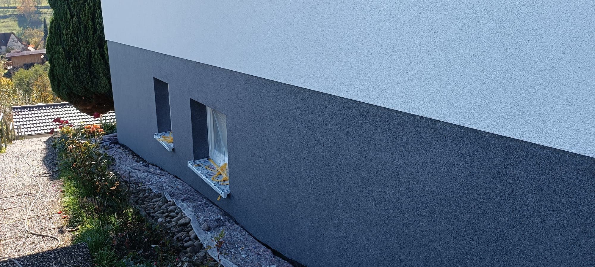 Fertig verputzte Hausfassade in Blaugrau mit klaren Linien
