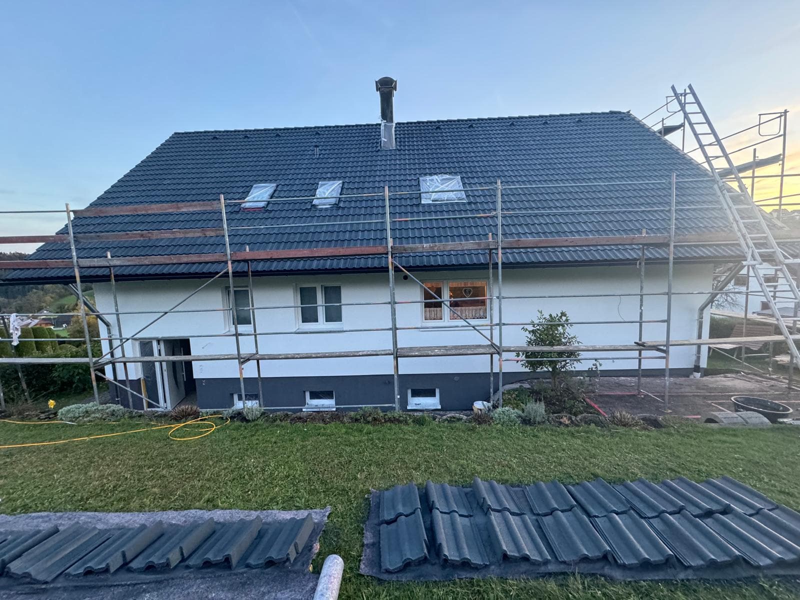 Eingerüstetes Haus mit bereitgelegten Dämmplatten für die Fassadendämmung