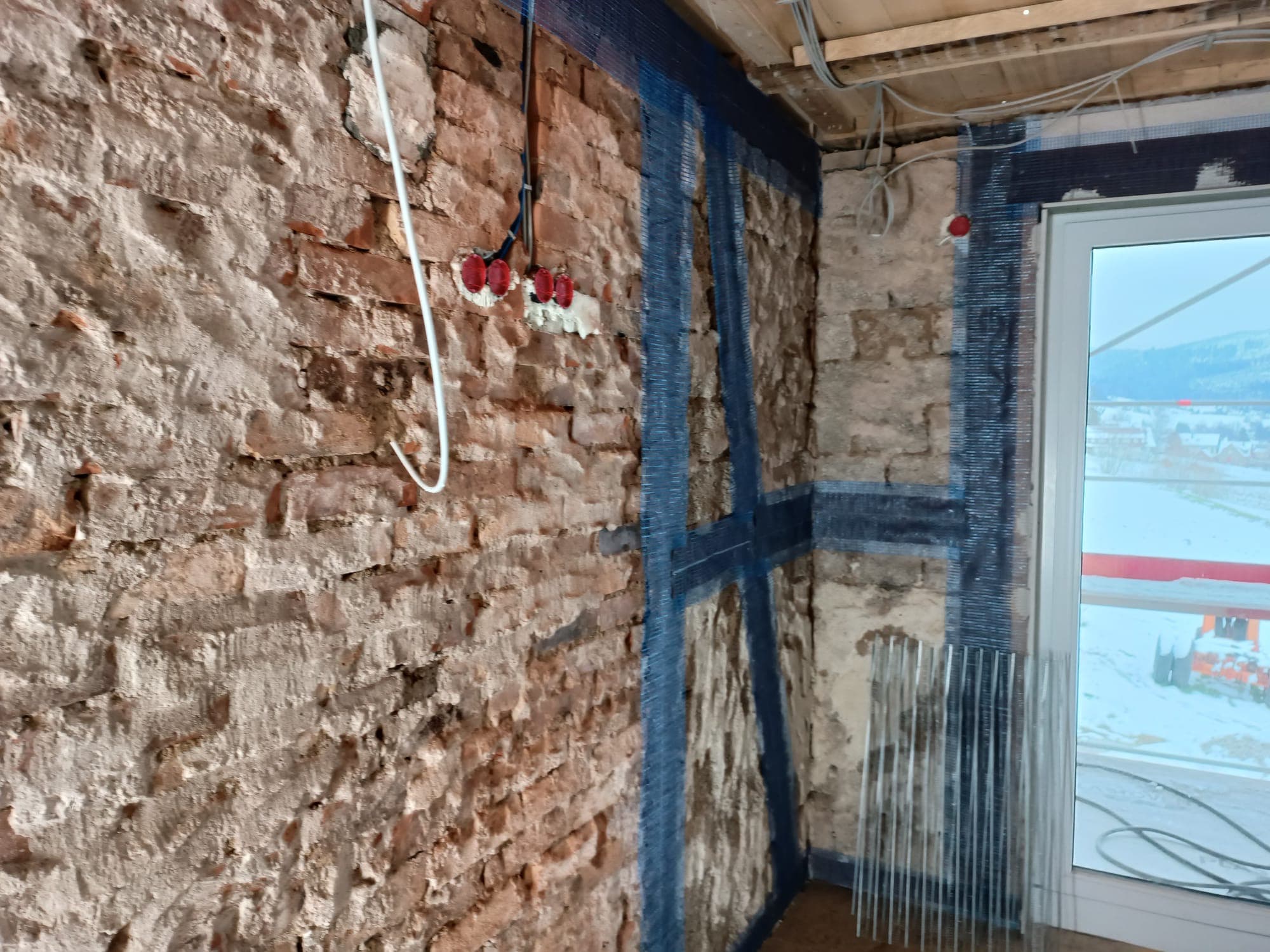 Freigelegtes Natursteinmauerwerk mit vorbereiteter Elektroinstallation in einem Altbau