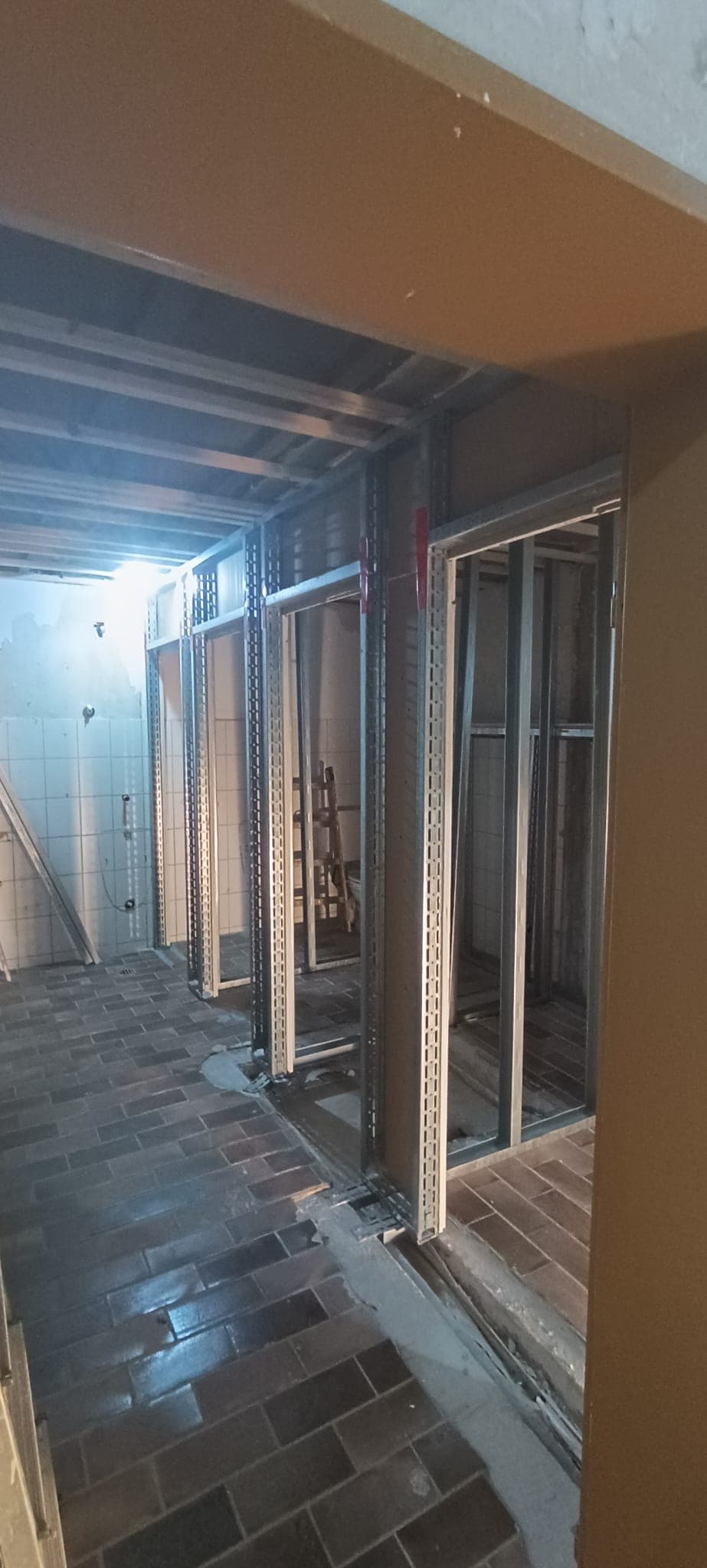 Fertig ausgebauter, hell erleuchteter Flur mit Trockenbauwänden und Glastüren