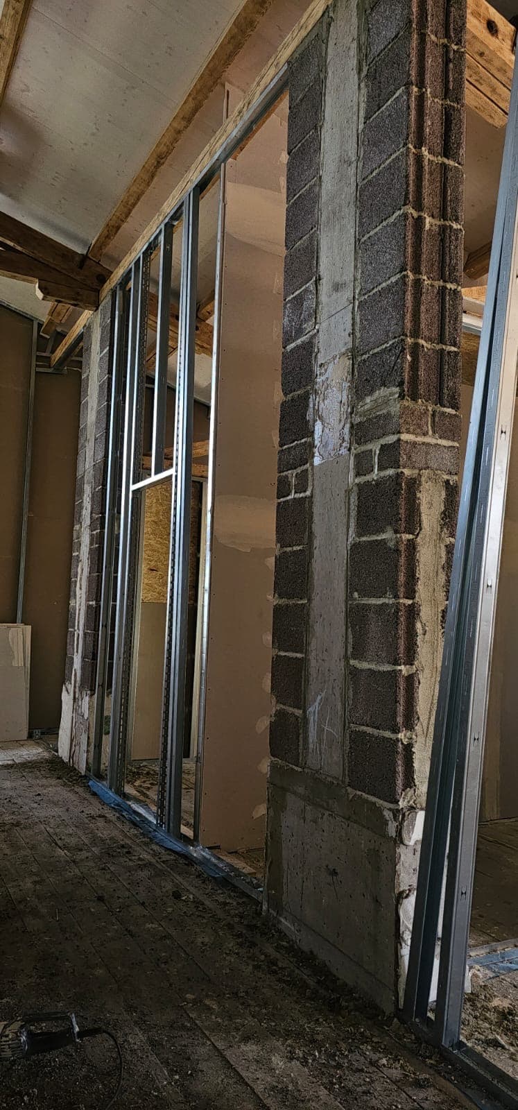 Metallständerwerk für Trockenbau vor einer alten Ziegelwand